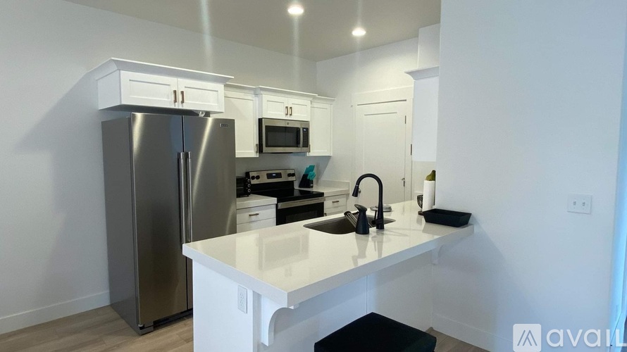 A kitchen with white cabinets and a stainless steel refrigerator.