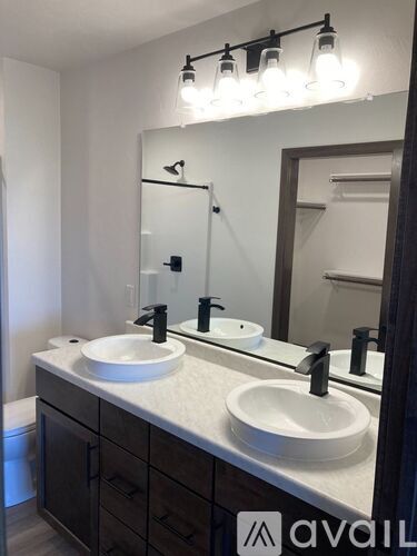 A bathroom with a white sink and a mirror above it.
