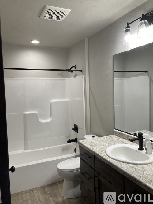 A bathroom with a white toilet, a white sink, and a white bathtub.