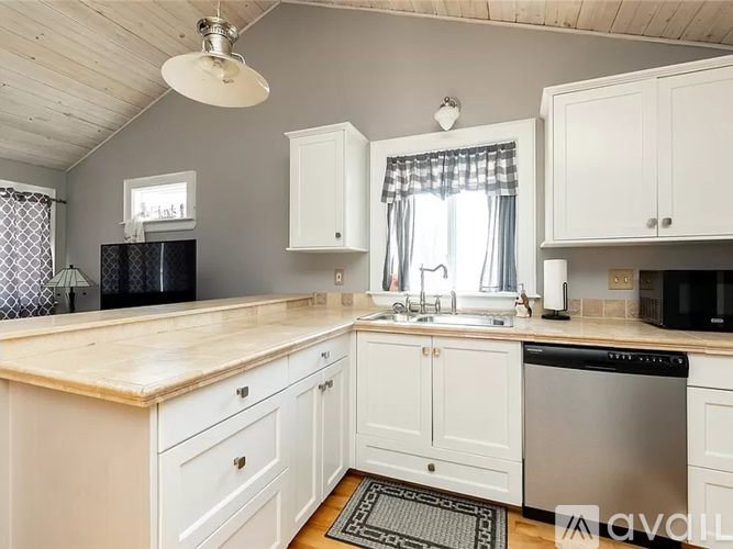 A kitchen with white cabinets and a wooden countertop.