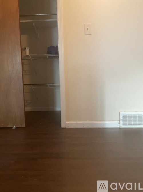 A room with a white wall and a wooden floor.