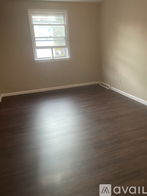 A room with wooden flooring and a window.