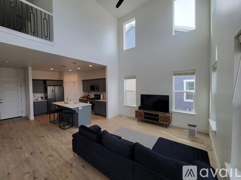 A living room with a black couch and a television on a wooden stand.
