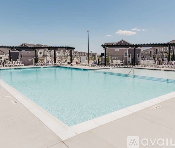 A large swimming pool in front of a building with a clear blue sky above.
