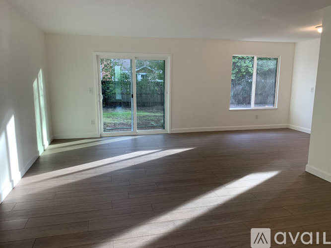 A room with wooden flooring and a large window.