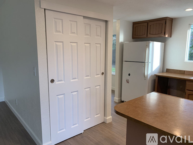 A white door with a brown handle is in a room with a wooden table.