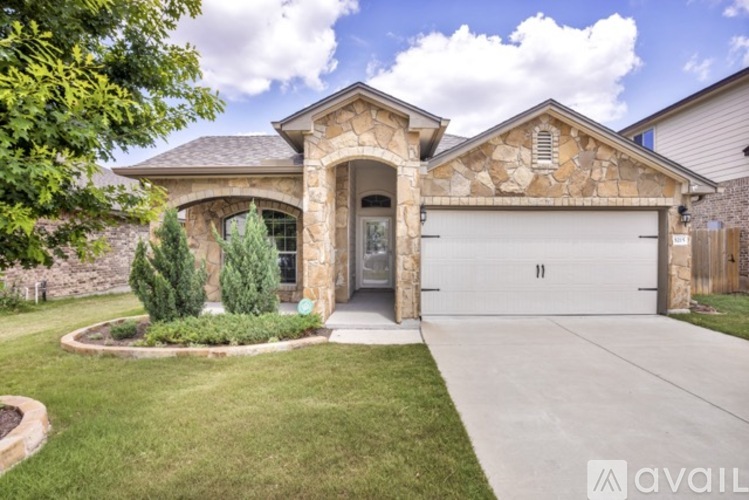 A house with a stone facade and a large front yard.