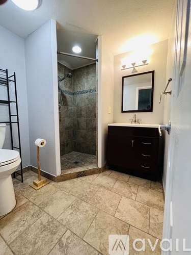 A bathroom with a toilet, sink, and shower.