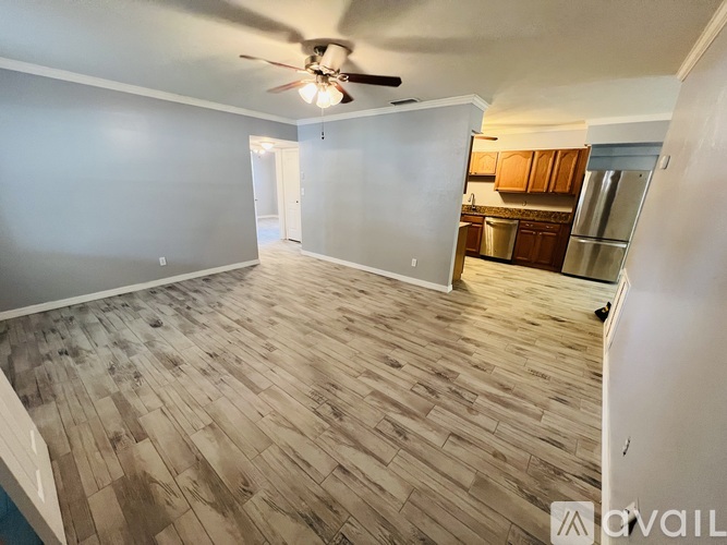 A room with wooden flooring and a ceiling fan.