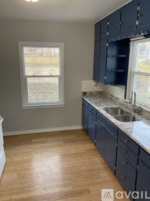 A kitchen with dark blue cabinets and a window.