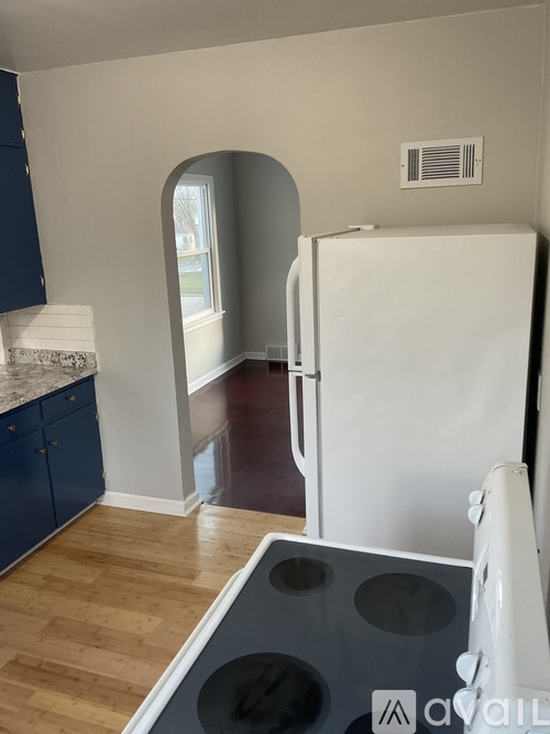 A kitchen with a white fridge and blue cabinets.
