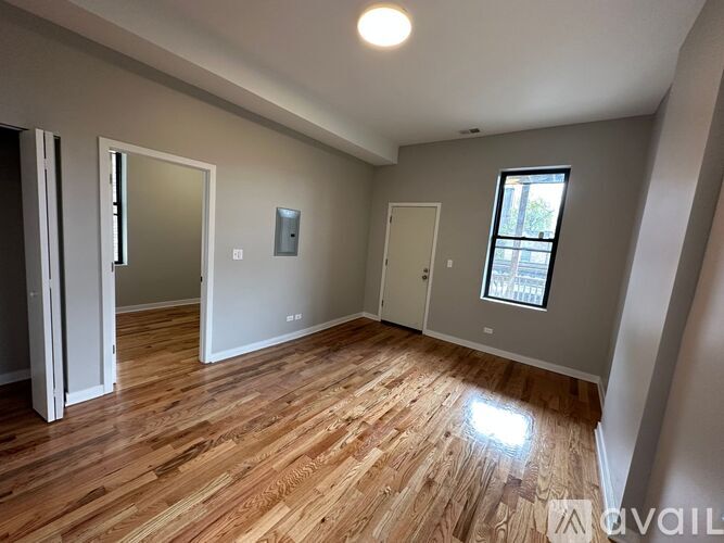 A room with wooden flooring and a window.