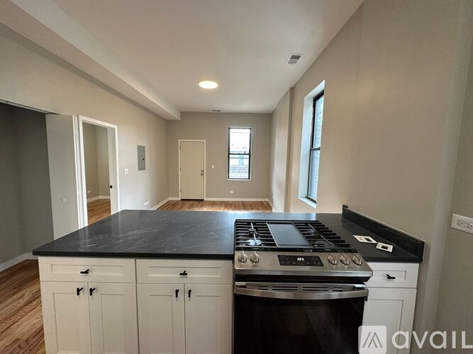 A kitchen with a black countertop and white cabinets.