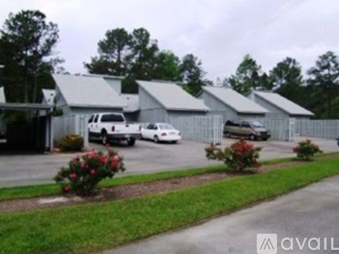 A row of houses with cars parked in front.