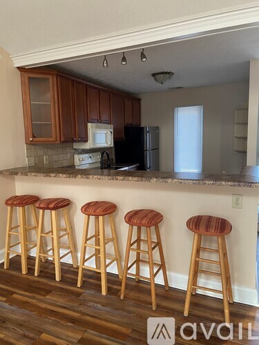 A kitchen with wooden cabinets and a black refrigerator.