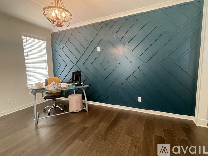 A room with a wooden floor and a wall with a chevron pattern.