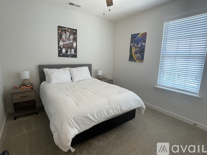 A bedroom with a large bed and two pictures on the wall.
