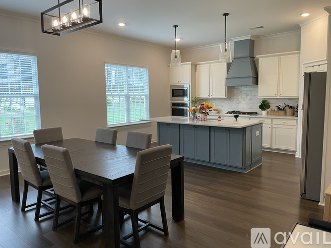 A modern kitchen with a dining table and chairs.