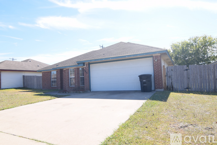 A house with a driveway and a trash can in front.