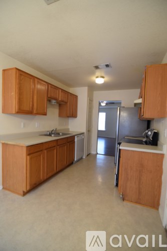 A kitchen with wooden cabinets and a refrigerator.