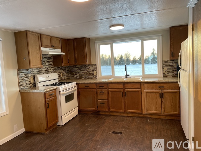 A kitchen with wooden cabinets and a stone backsplash.