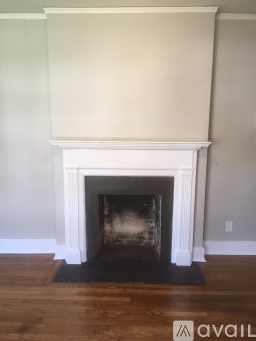 A fireplace with a black mat in front of it.