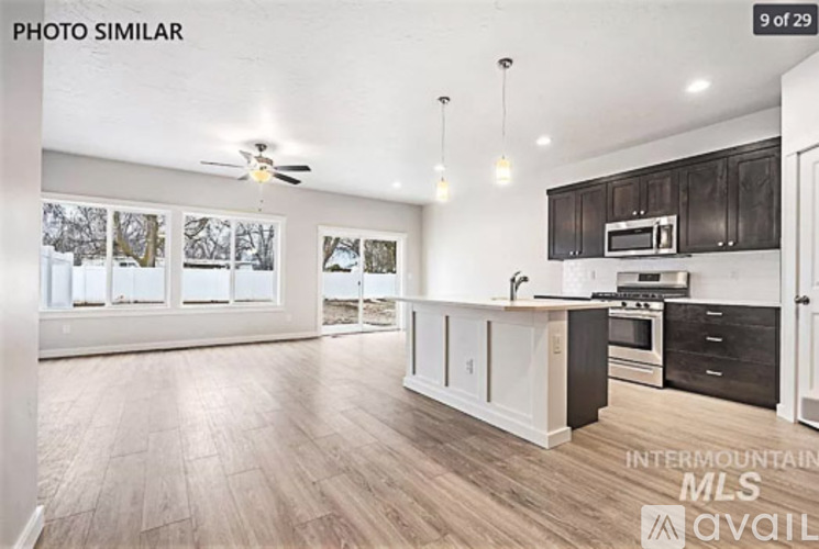 A spacious kitchen with dark wood cabinets and a white countertop.