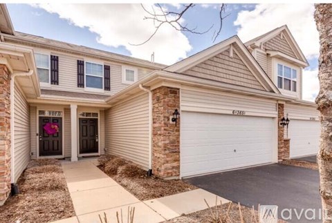 A house with a brown door and a white garage door.