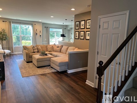 A living room with a couch, a coffee table, and a staircase.