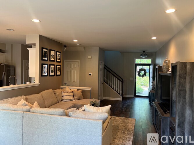 A living room with a couch and a staircase.