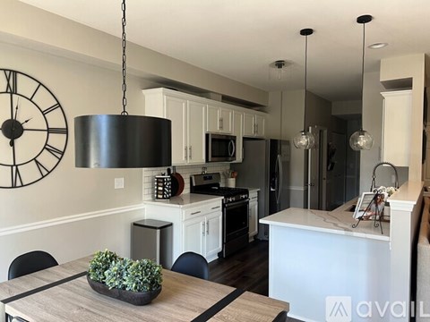 A modern kitchen with a large island and pendant lights.