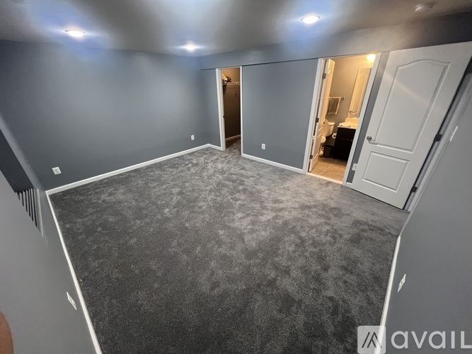 A room with grey carpet and white walls.