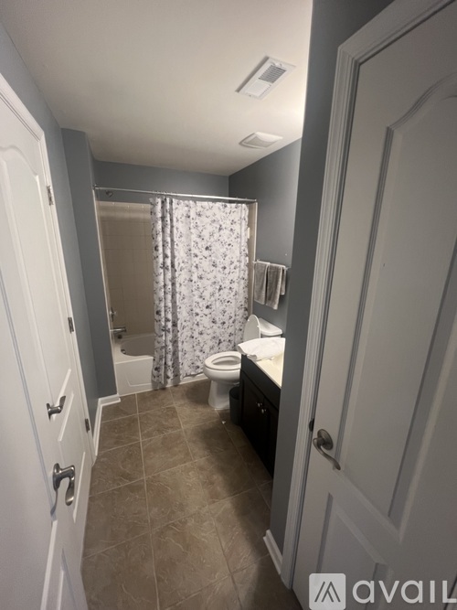 A bathroom with a toilet, sink, and shower curtain.