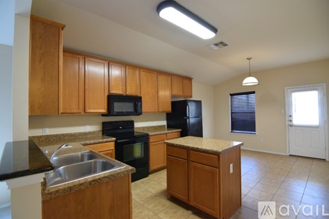 A kitchen with wooden cabinets and black appliances.