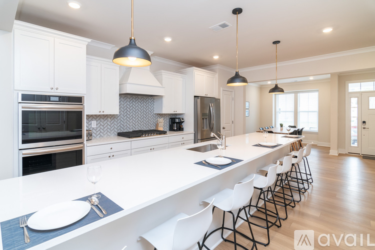 A modern kitchen with white cabinets and a long island.