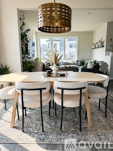 A dining room with a round table and chairs.