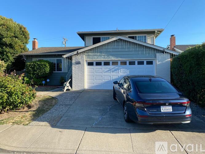 A house with a garage and a car parked in front.