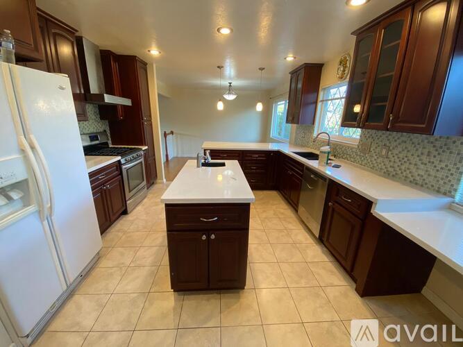 A kitchen with a white refrigerator and brown cabinets.
