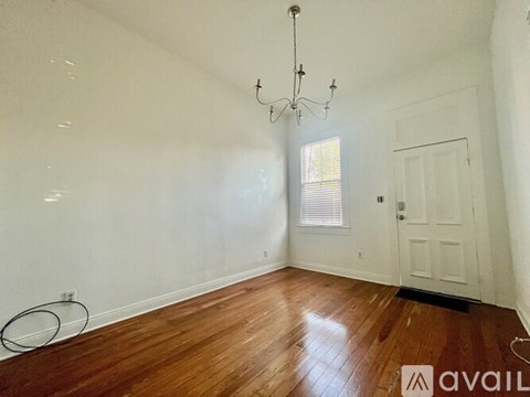 A room with a chandelier, a door, and a window.