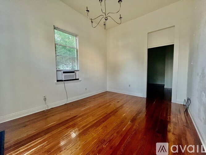 A room with wooden floors and a chandelier.