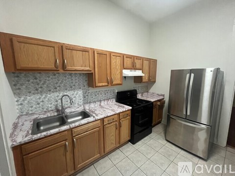 A kitchen with wooden cabinets and a marble countertop.