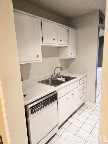 A kitchen with white appliances and cabinets.