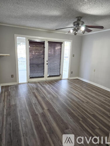 A room with wooden flooring and a ceiling fan.