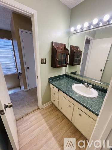 A bathroom with a sink, mirror, and lighting.