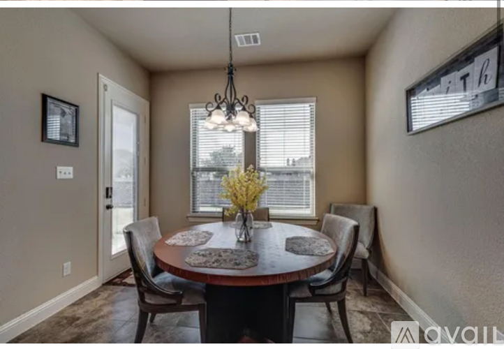 A dining room with a round table and chairs.