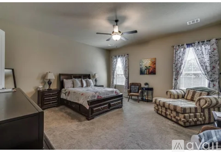 A bedroom with a large bed and a couch.
