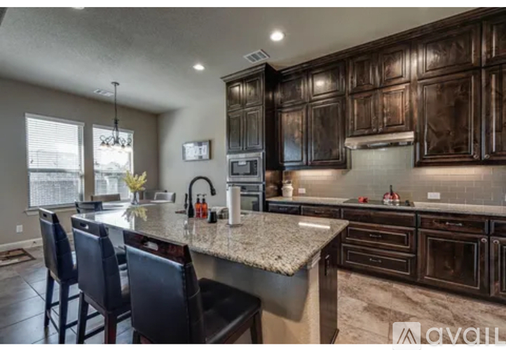 A kitchen with dark wood cabinets and granite countertops.