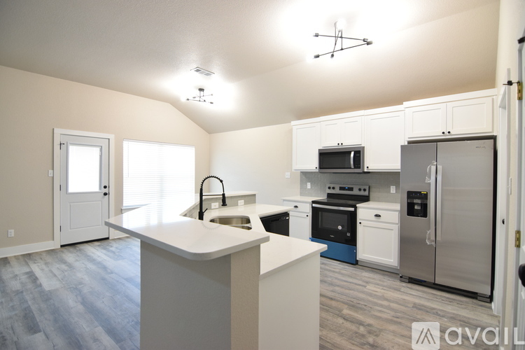A kitchen with a white countertop and stainless steel appliances.
