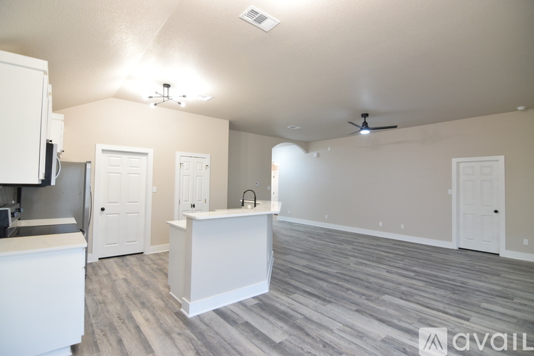 A kitchen area with a white counter and a white fridge.
