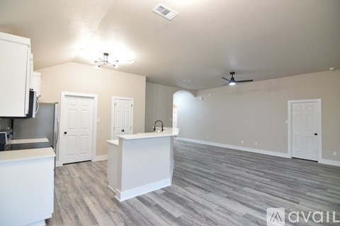 A kitchen area with a white counter and a white fridge.